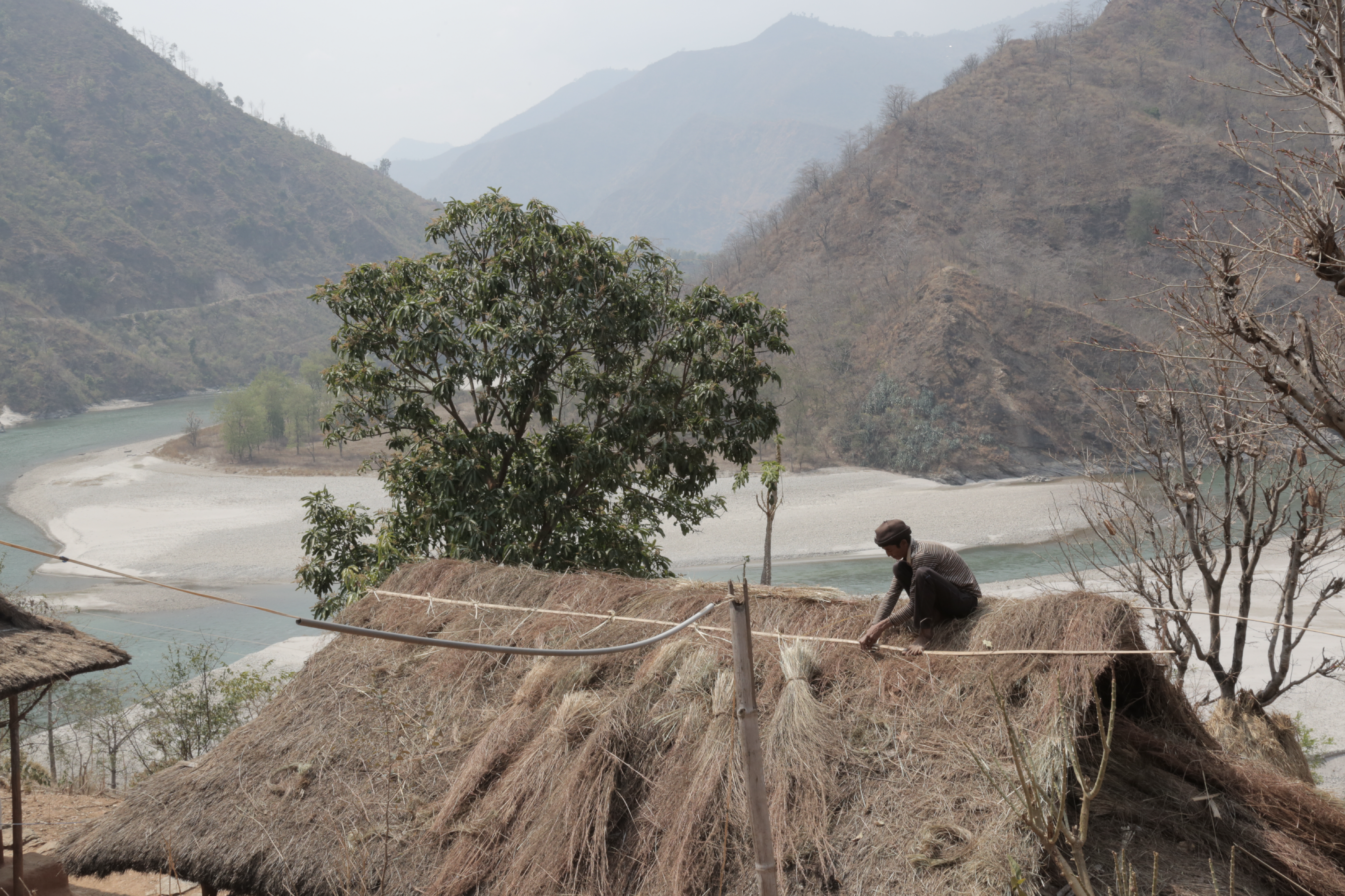 Man on top of a house overlooking mountains